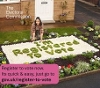 A person in their front garden with plants in the shape of words saying 'I'm registered to vote'